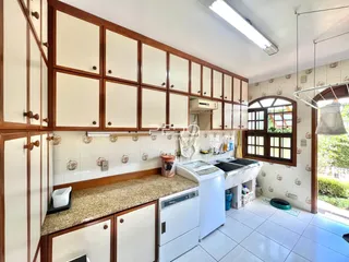 Foto de uma cozinha com armários de madeira e revestimento cerâmico.