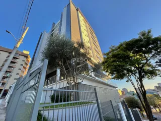 Fachada de um edifício residencial em Lajeado com vegetação ao redor.