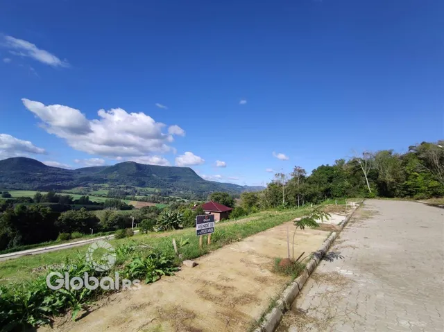 Vista panorâmica de paisagem montanhosa e campos verdes.