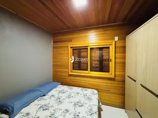 Quarto com paredes de madeira e armário em Lajeado.
