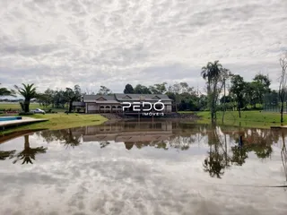 Vista da fachada de uma propriedade em Lajeado, Brasil, refletida na água.