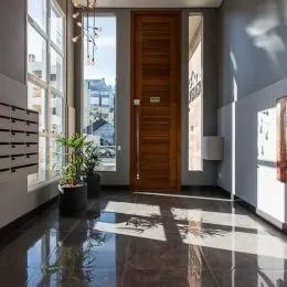 Hall de entrada com piso polido e grande janela.