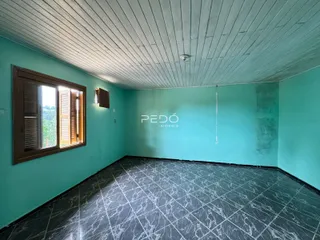 Ambiente interno de uma sala com paredes turquesa e piso de cerâmica escura.