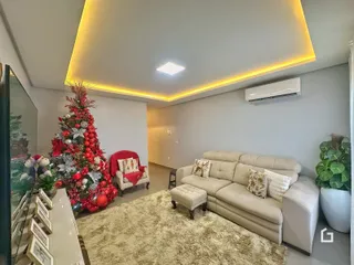 Sala de estar decorada com árvore de Natal e sofá.