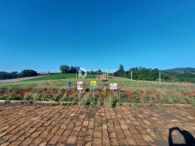 Paisagem de campo com sinais de venda em uma área rural.