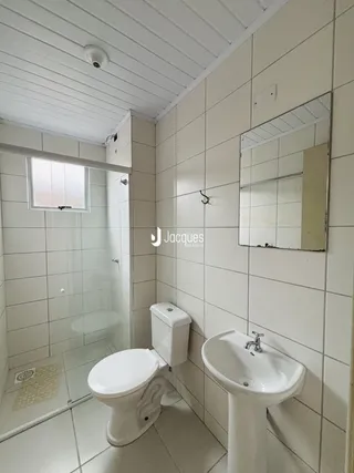 Interior de um banheiro com revestimento cerâmico branco.