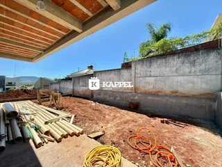 Vista externa de um terreno com tubos e materiais de construção.