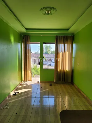 Uma sala interna com paredes verdes e piso de cerâmica.