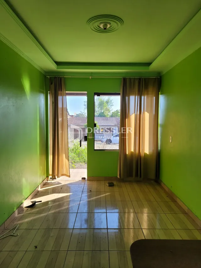 Uma sala interna com paredes verdes e piso de cerâmica.
