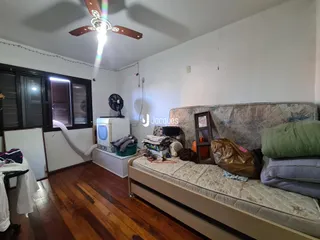 Foto de um quarto com cama e piso de madeira.