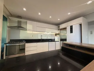 Cozinha moderna com armários brancos e bancadas escuras.