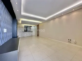 Interior de uma sala de estar moderna com piso claro e iluminação embutida.