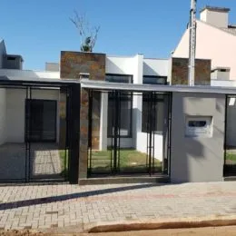Fachada moderna de uma residência em Lajeado, Brasil, com grandes janelas escuras.