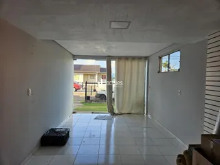 Hall de entrada com piso de cerâmica e paredes brancas.