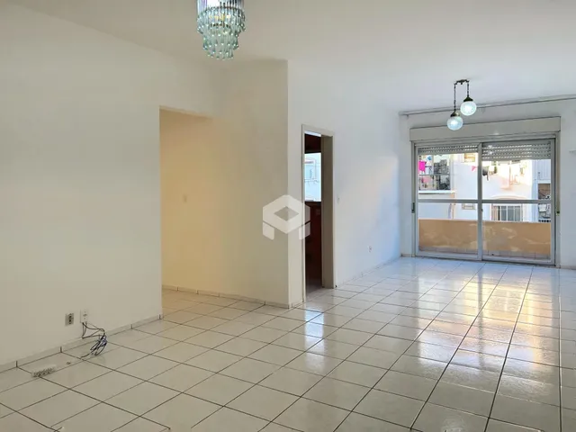 Ambiente interno de uma sala ampla com piso de cerâmica e paredes brancas.