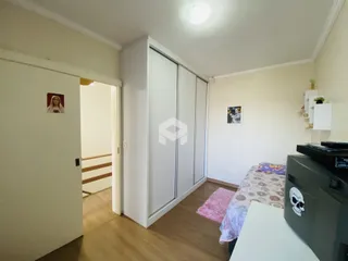 Quarto com armário branco e piso de madeira em imóvel no Brasil.