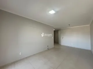 Hall de entrada com paredes brancas e piso de cerâmica claro.
