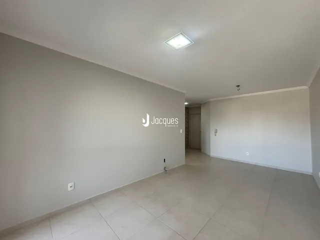Hall de entrada com paredes brancas e piso de cerâmica claro.