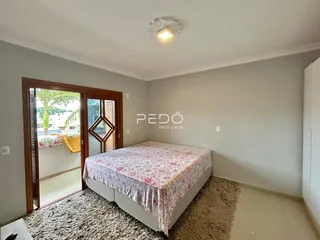 Quarto com cama e porta de madeira no interior da residência.
