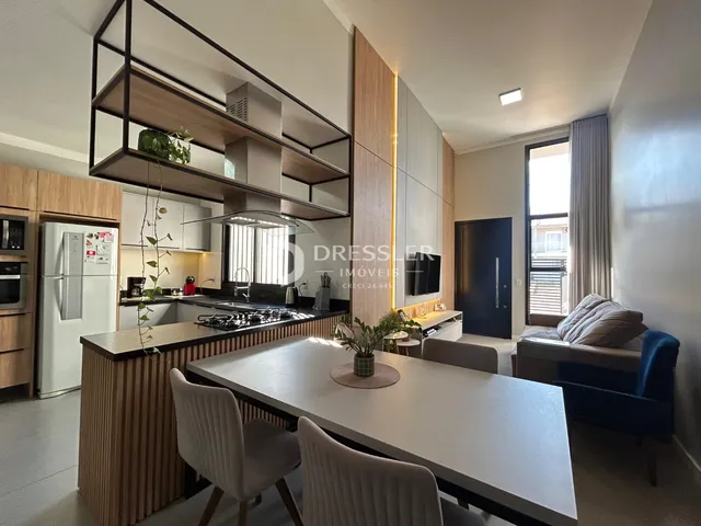 Interior de uma sala de estar com cozinha moderna em Lajeado.