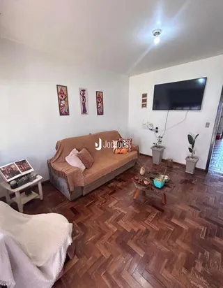 Sala de estar com sofá e piso de madeira no interior da residência.