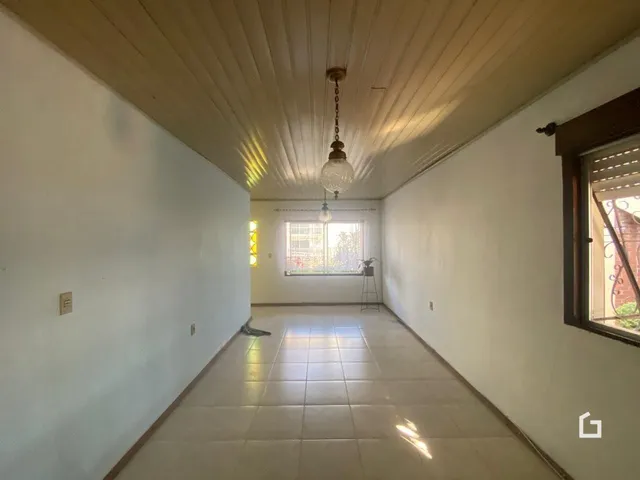 Corredor interno de uma residência com piso de cerâmica e teto de gesso.
