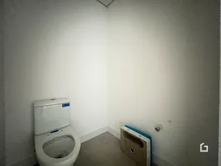 Interior de um cômodo com parede branca e vaso sanitário.