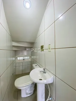 Foto interna de um banheiro com azulejos brancos.