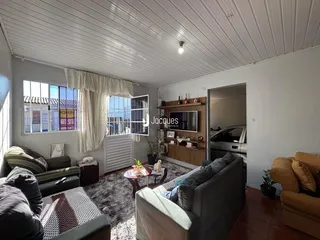 Sala de estar com sofá e piso de madeira em um imóvel no Brasil.