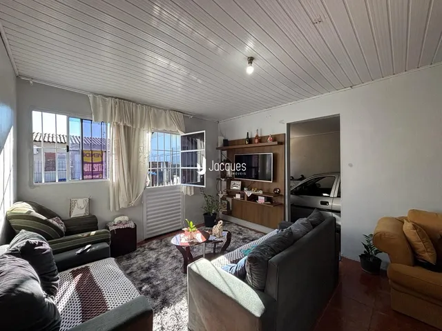 Sala de estar com sofá e piso de madeira em um imóvel no Brasil.