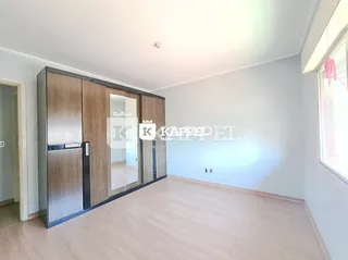 Foto de um cômodo interno com piso de madeira e armários embutidos.