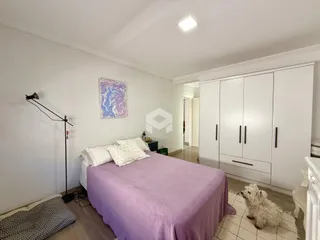 Quarto com cama e armários brancos em um imóvel no Brasil.