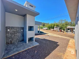 Fachada de uma casa moderna em Lajeado, Brasil, com área externa pavimentada.