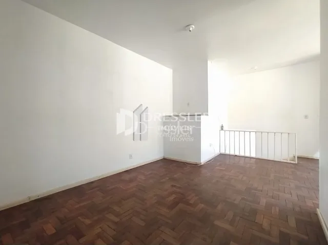 Ambiente interno de uma sala com piso de madeira.