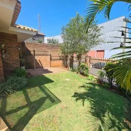 Foto de uma área externa gramada com vegetação.