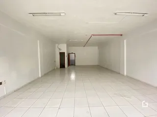 Ambiente interno amplo com piso de cerâmica e paredes brancas.