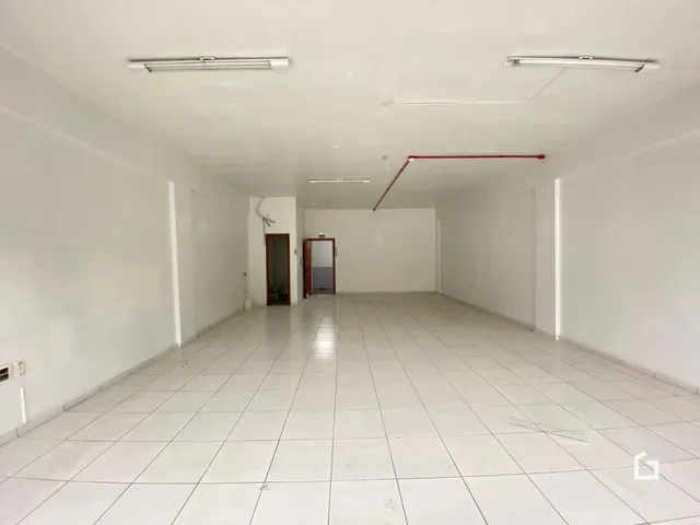 Ambiente interno amplo com piso de cerâmica e paredes brancas.