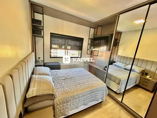 Quarto com cama grande e cabeceira estofada em um ambiente bem iluminado.