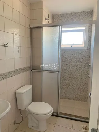 Foto de um banheiro com revestimento cerâmico e porta de vidro.