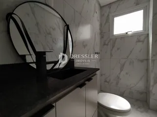 Foto de um banheiro com revestimento em mármore e vaso sanitário branco.