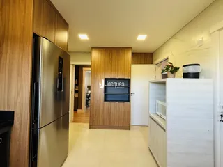 Interior de uma cozinha moderna com armários de madeira e eletrodomésticos de aço inoxidável.