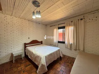Quarto com paredes de tijolo aparente e piso de cerâmica.