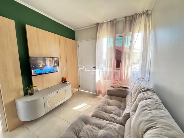 Sala de estar com sofá e painel de madeira na residência.