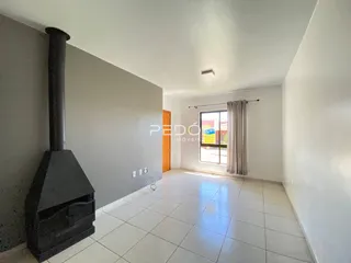 Vista de um ambiente interno com paredes brancas e piso de cerâmica.