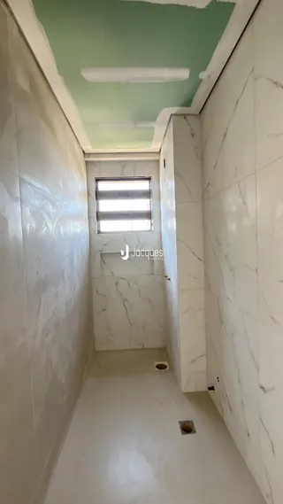 Corredor interno com paredes brancas e teto verde claro.