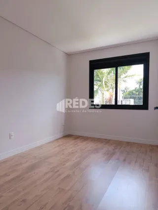 Sala de estar com piso de madeira clara e janela.