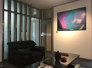 Sala de estar com sofá de couro e arte na parede.