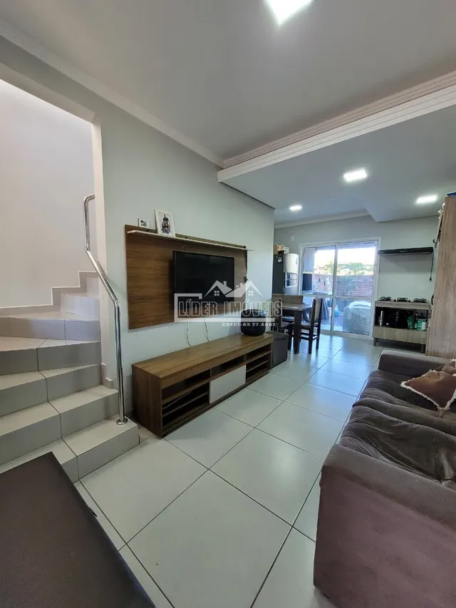 Sala de estar com escadaria e piso de cerâmica em um imóvel no Brasil.