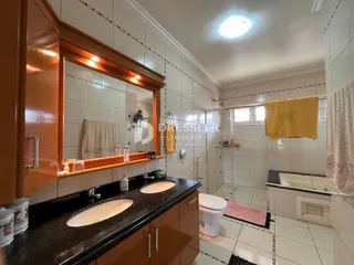 Foto de um banheiro com revestimento cerâmico e bancada escura.
