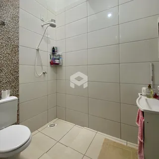 Foto de um banheiro com revestimento cerâmico branco.